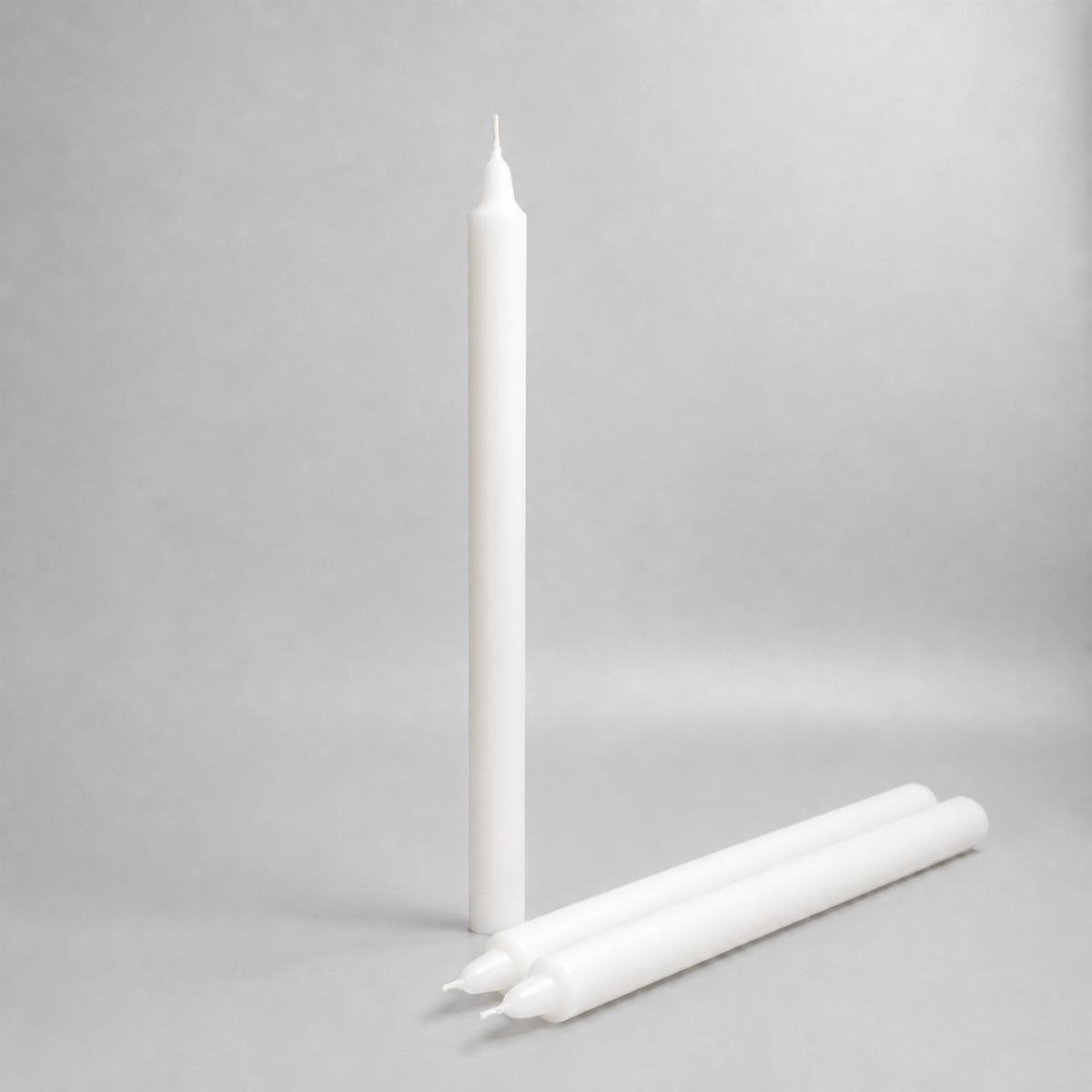 Three white straight wax pillar candles