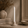 White straight pillar candle in a holder at home