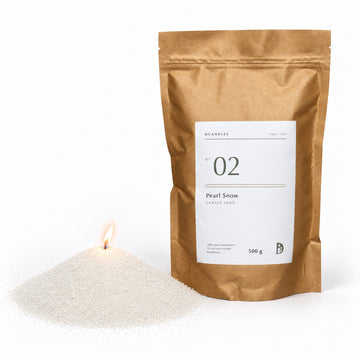 Candle sand N° 02 Pearl Snow, lit, next to its kraft bag