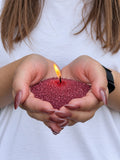 Candle sand N° 04 Velvet Burgundy burning in cupped hands