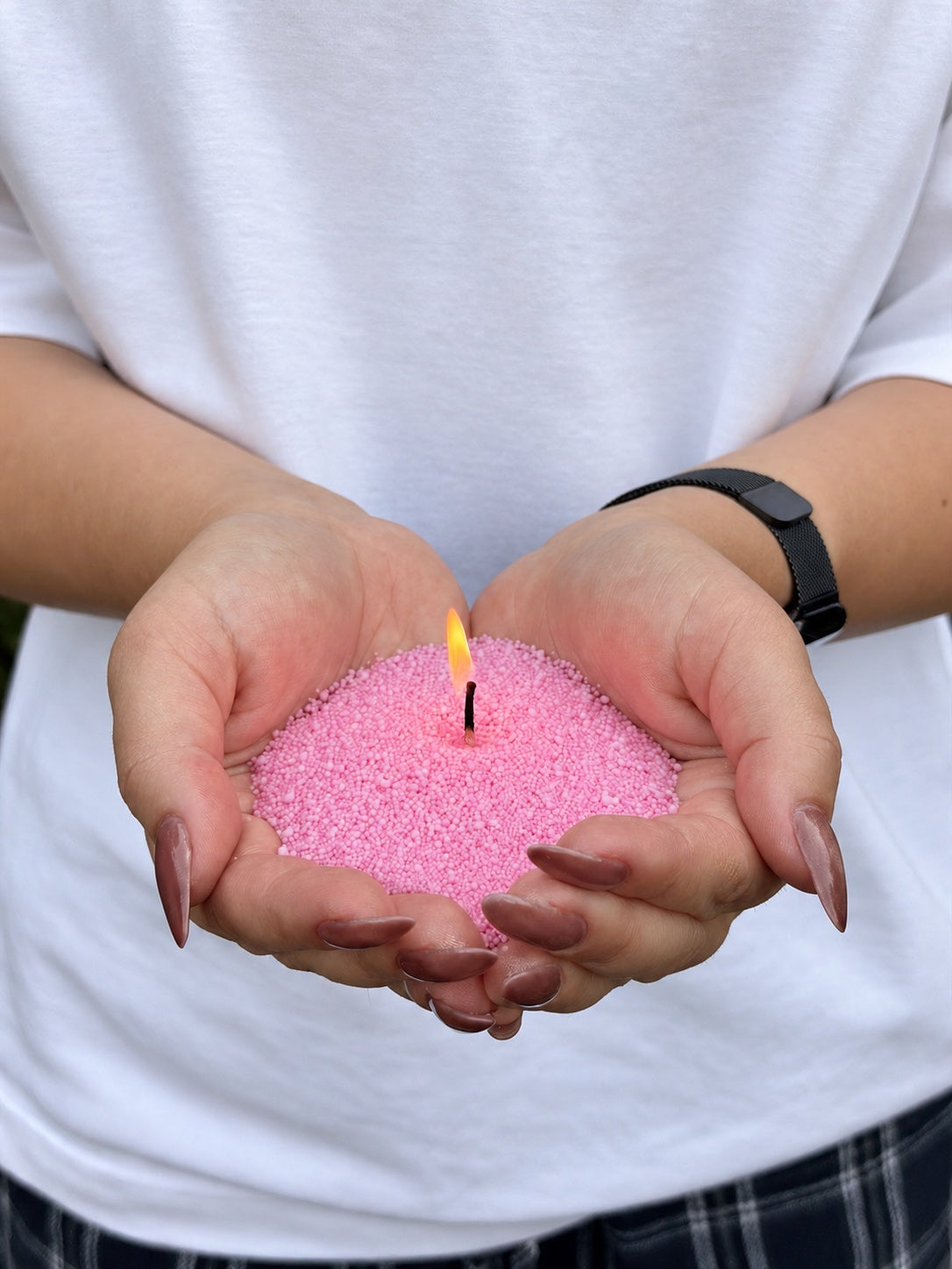 Candle sand N° 05 Rose Quartz burning in cupped hands