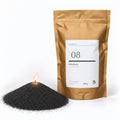 Kerzensand N° 08 Obsidian, brennend, neben dem Kraftbeutel