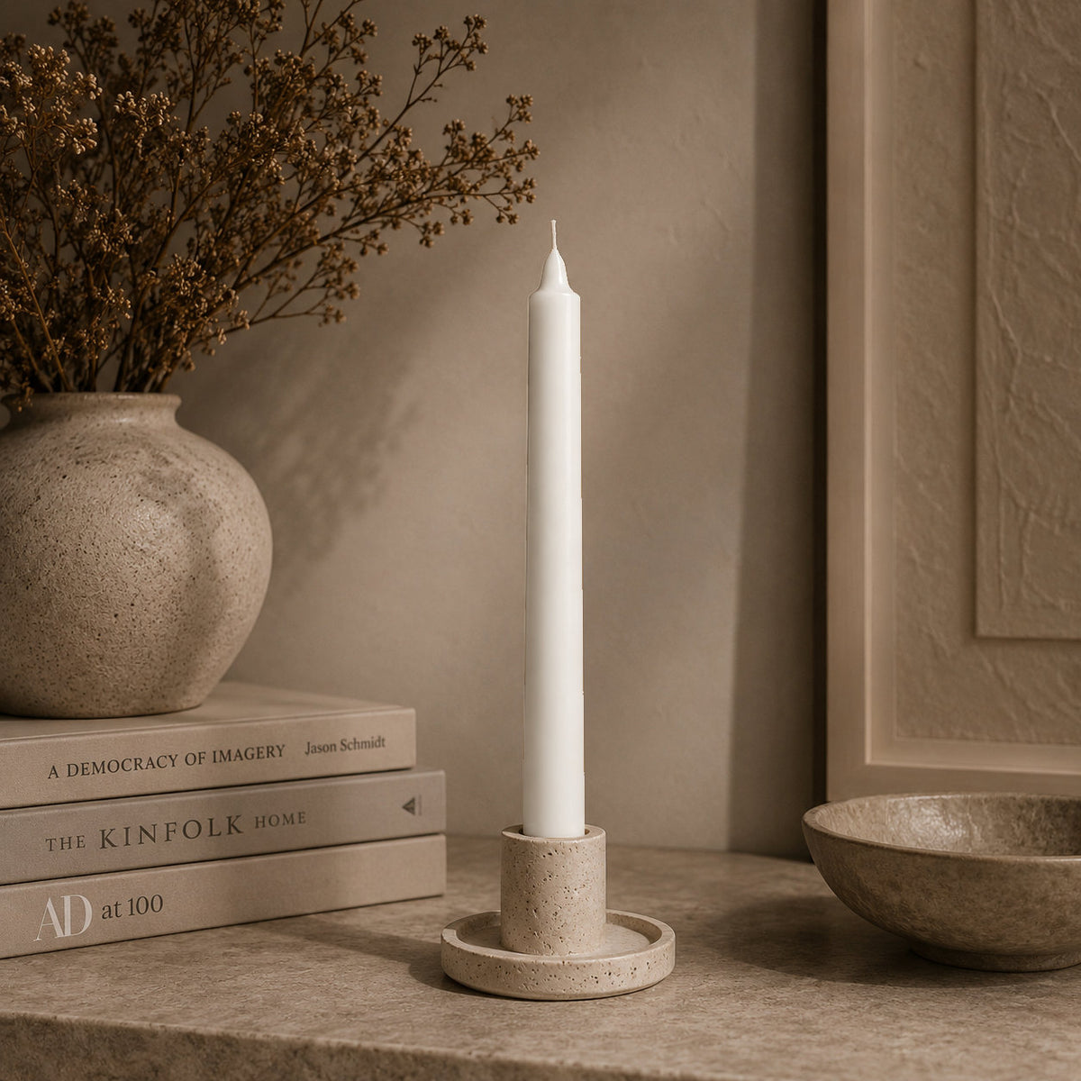 White straight pillar candle in a stone holder at home