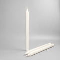 One standing and two lying white pillar candles