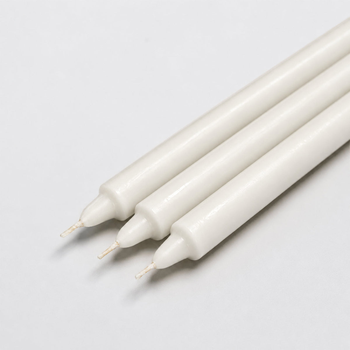 Close-up of three white pillar candles